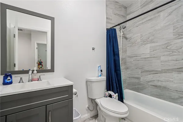 a bathroom with a bathtub shower sink mirror vanity and toilet
