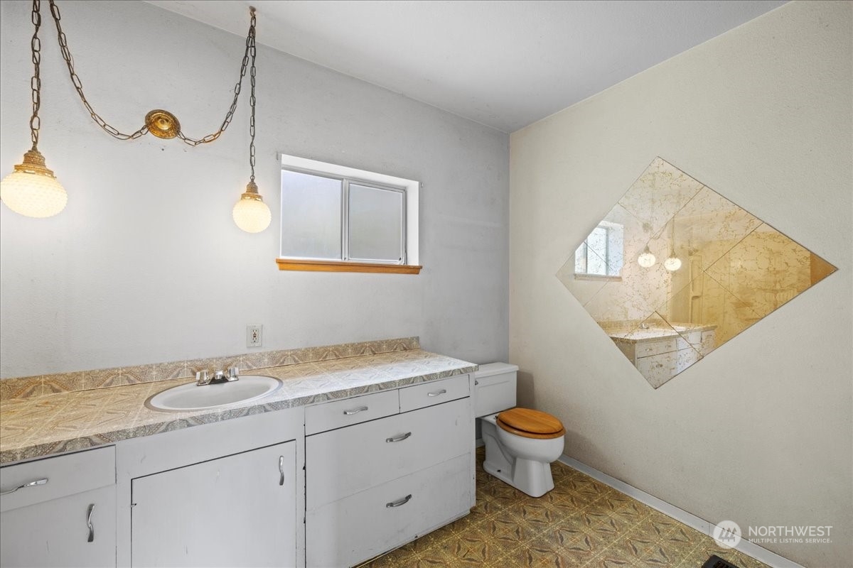 703 Washington Street Walla Walla, WA 99362 - Photo 9 of 30 a bathroom with a granite countertop sink a toilet and a mirror