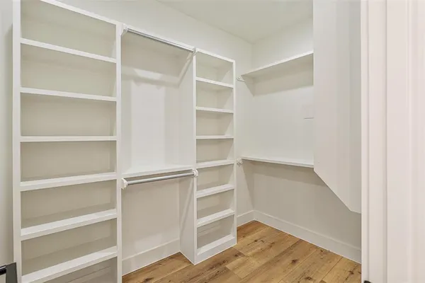 a view of walk in closet with empty racks