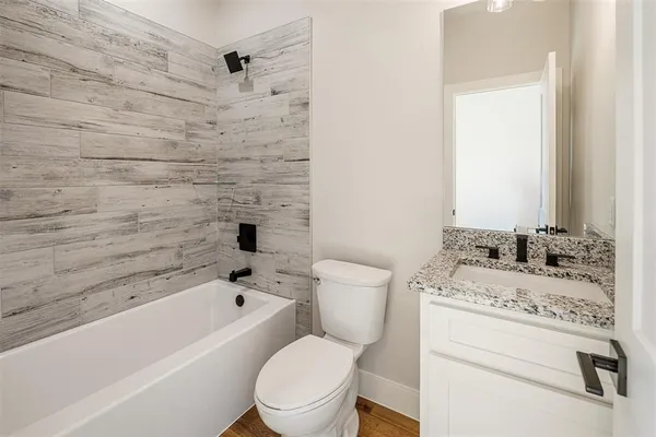 a bathroom with a toilet sink a mirror and bathtub