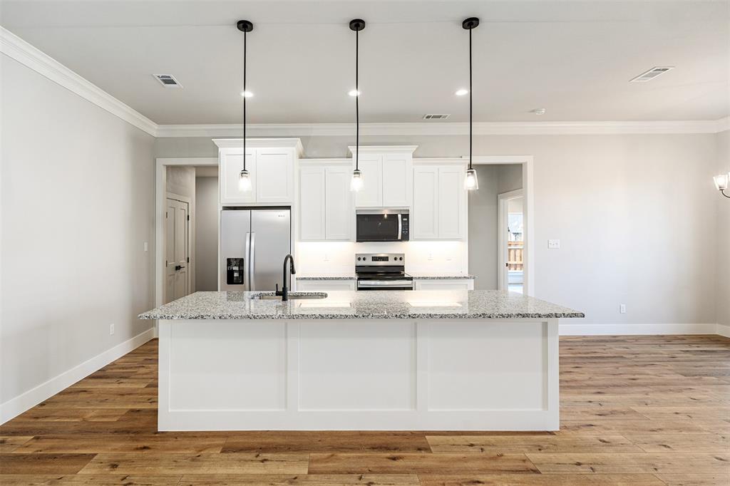 502 Limestone Circle Mabank, TX 75147 - Photo 7 of 38 a view of a kitchen with kitchen island a sink stainless steel appliances and cabinets