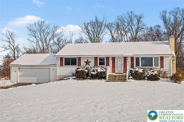 a front view of a house with a yard covered in snow