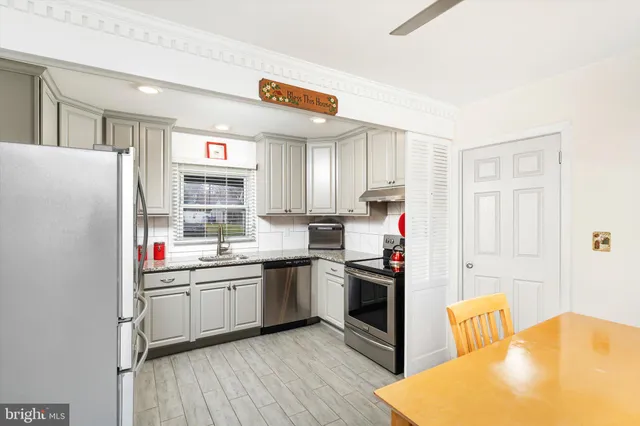 a kitchen with cabinets appliances a sink and a window