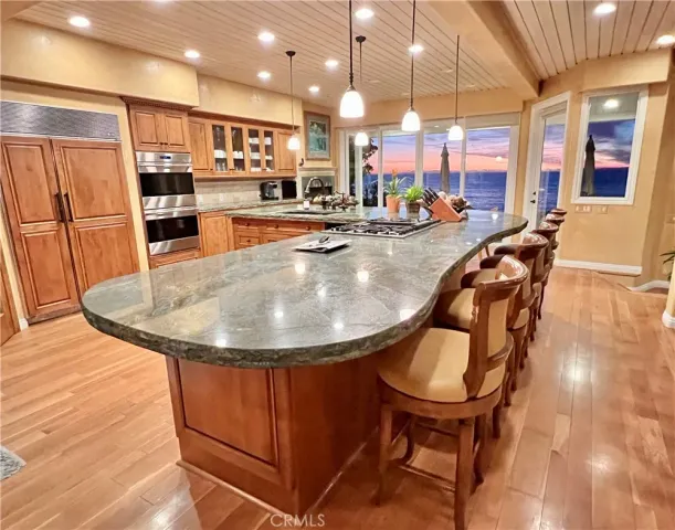 a large kitchen with stainless steel appliances granite countertop a large stove top oven and cabinets