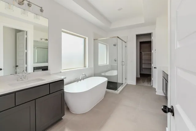 a spacious bathroom with a double vanity sink mirror and bathtub