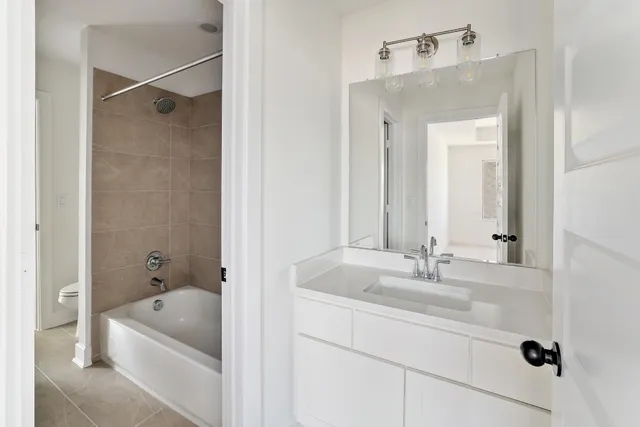 a bathroom with a tub a sink and mirror