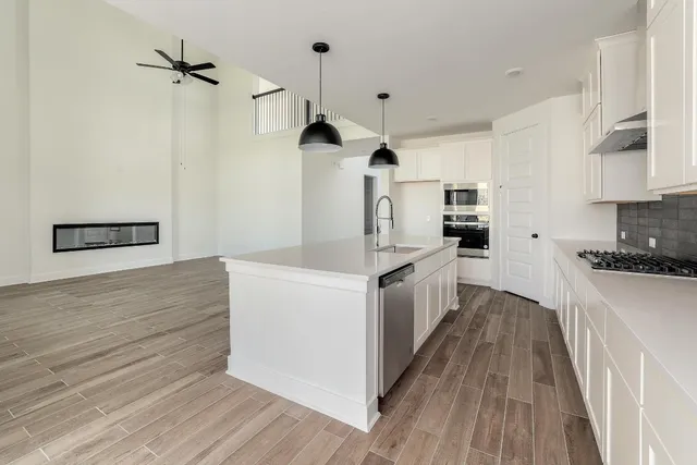 a kitchen with white cabinets and stainless steel appliances