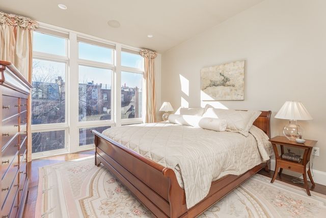 a large bed sitting in a bedroom next to a large window