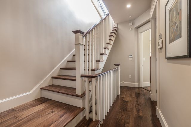a view of staircase with wooden floor and white walls