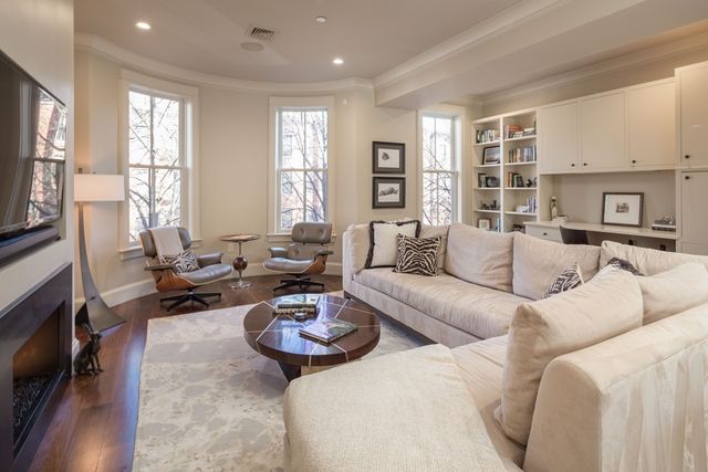 a living room with furniture kitchen view and a window