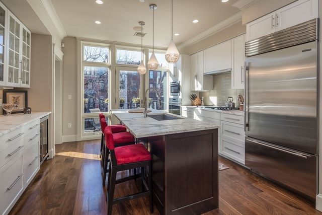 a kitchen with stainless steel appliances granite countertop a kitchen island hardwood floor sink stove dining table and chairs