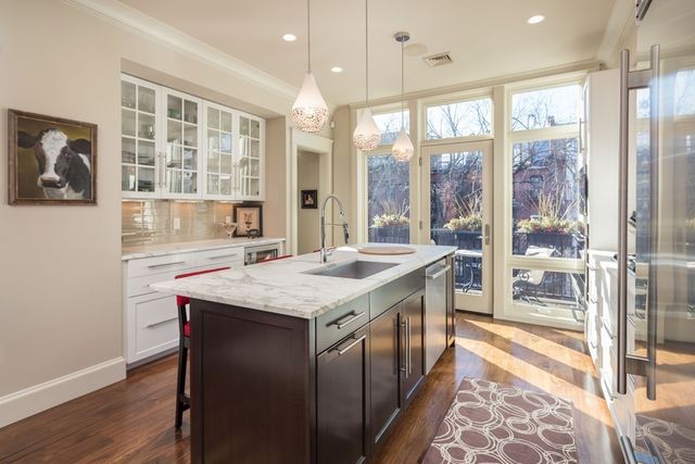 a kitchen with stainless steel appliances granite countertop a stove and a large window