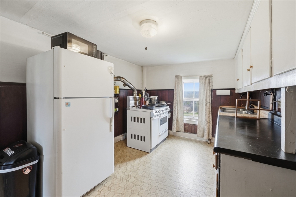 16 Main Street Brookfield, MA 01506 - Photo 25 of 45 a kitchen with a refrigerator a stove top oven a washer and dryer