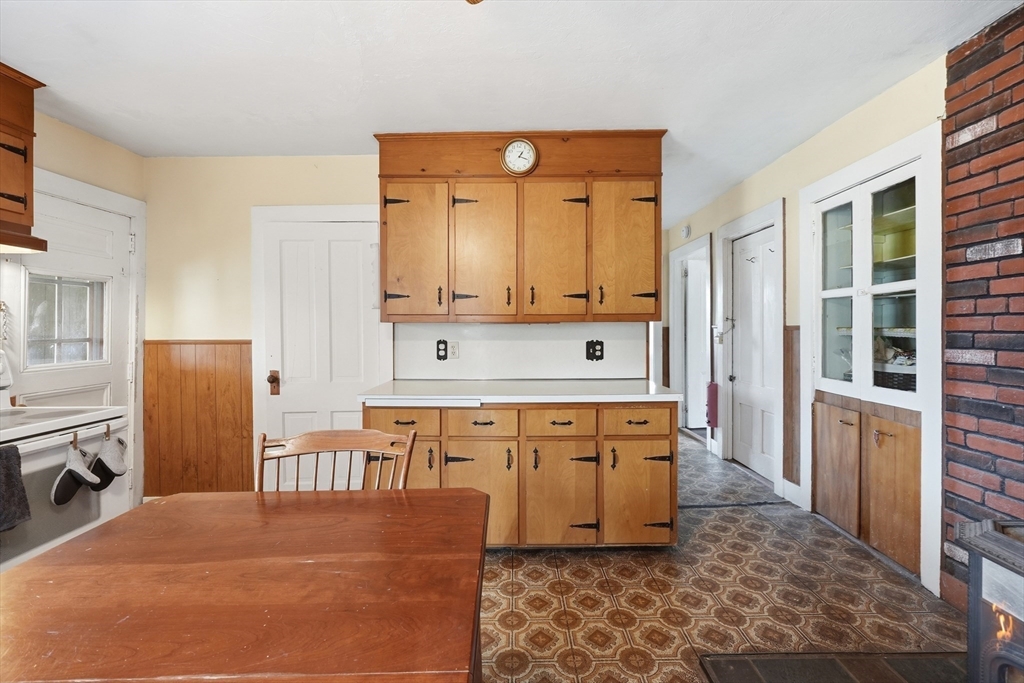 16 Main Street Brookfield, MA 01506 - Photo 10 of 45 a large kitchen with stainless steel appliances a refrigerator a stove a sink and a dining table with wooden floor