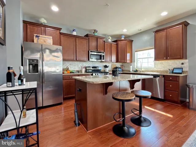 a kitchen with stainless steel appliances a sink a counter top space cabinets and a window