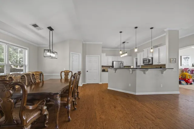 a kitchen with stainless steel appliances granite countertop a sink a stove and a wooden floors