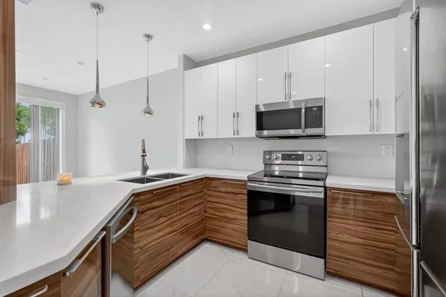 a view of a kitchen with refrigerator and more cabinets
