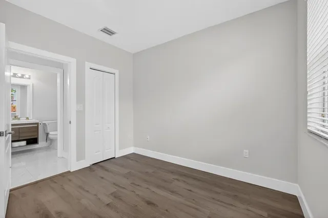 a view of an empty room with wooden floor