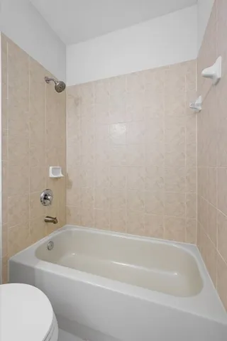 a white bath tub sitting next to a shower