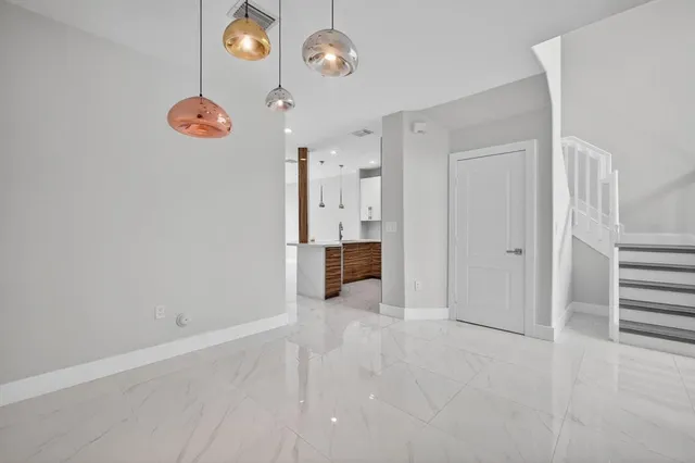 a view of a room with large windows and plants