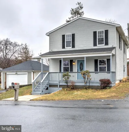 a front view of a house with swimming pool table and chairs