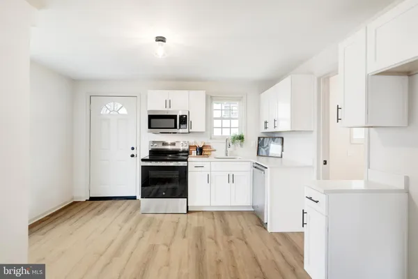 a kitchen with cabinets stainless steel appliances and a window