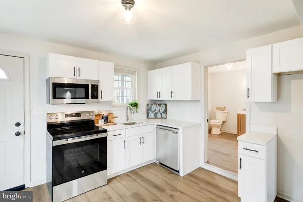 a kitchen with stainless steel appliances a stove a sink and a microwave