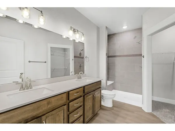 a bathroom with a double vanity sink toilet and shower