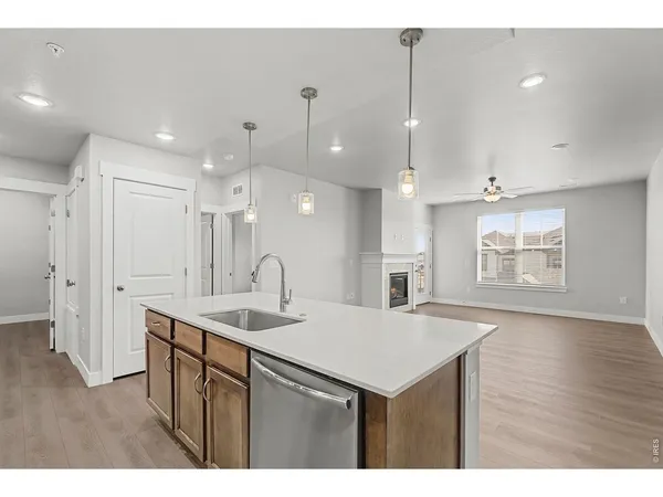 a kitchen with a sink chandelier and wooden floor