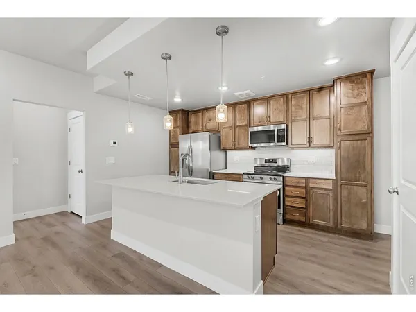 a kitchen with kitchen island white cabinets and stainless steel appliances