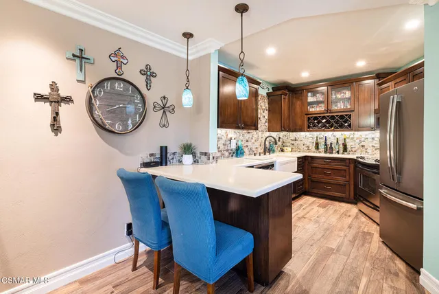 a kitchen with a refrigerator a sink and a stove with wooden floor