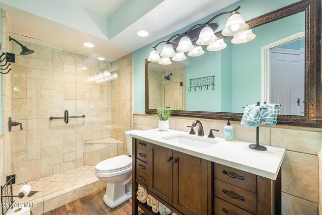 a bathroom with a double vanity sink mirror and toilet