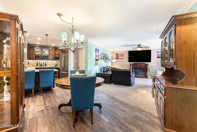 a living room with furniture a flat screen tv and kitchen view