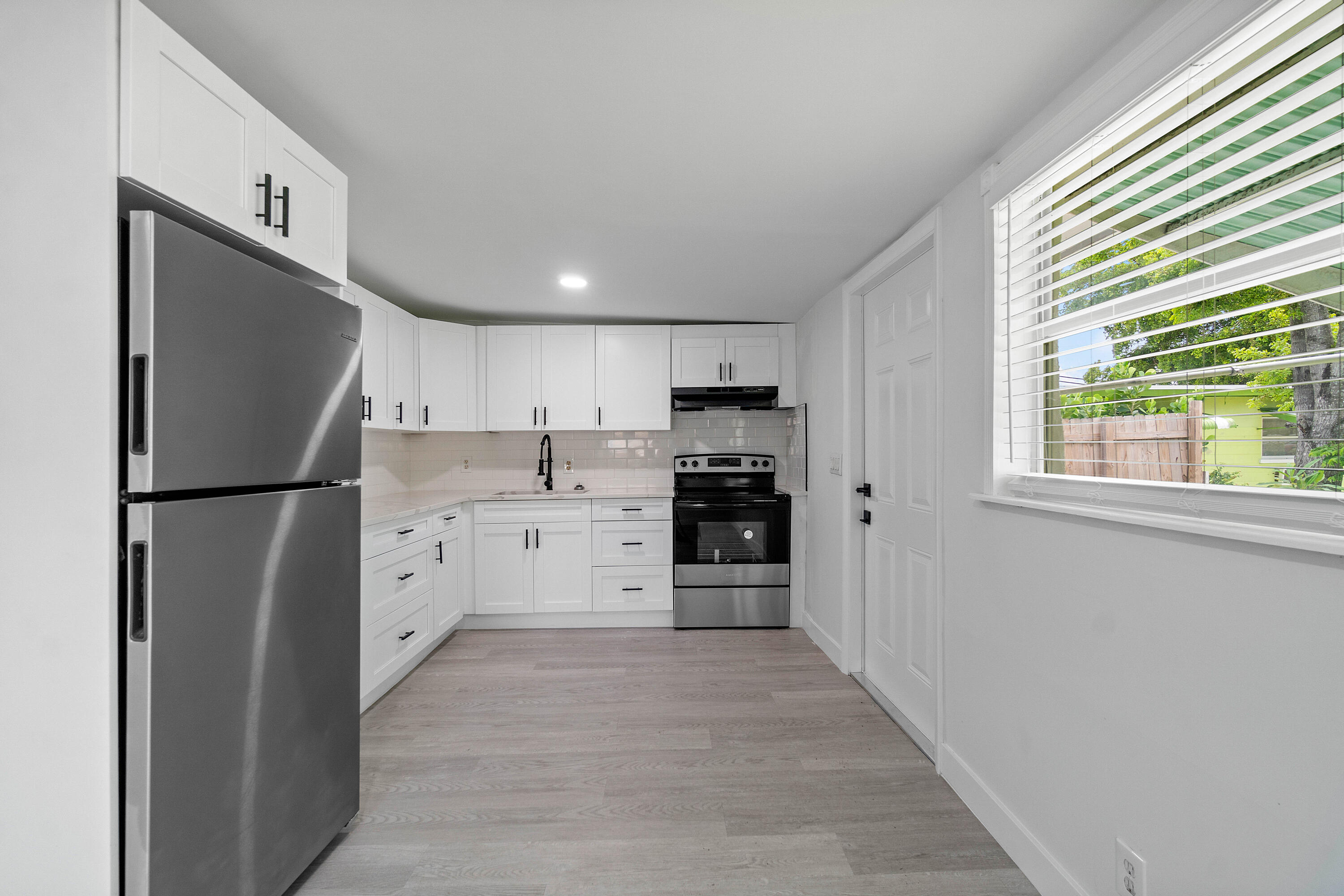 137 Southwest 9th Avenue Delray Beach, FL 33444 - Photo 13 of 26 a kitchen with stainless steel appliances a refrigerator sink and cabinets