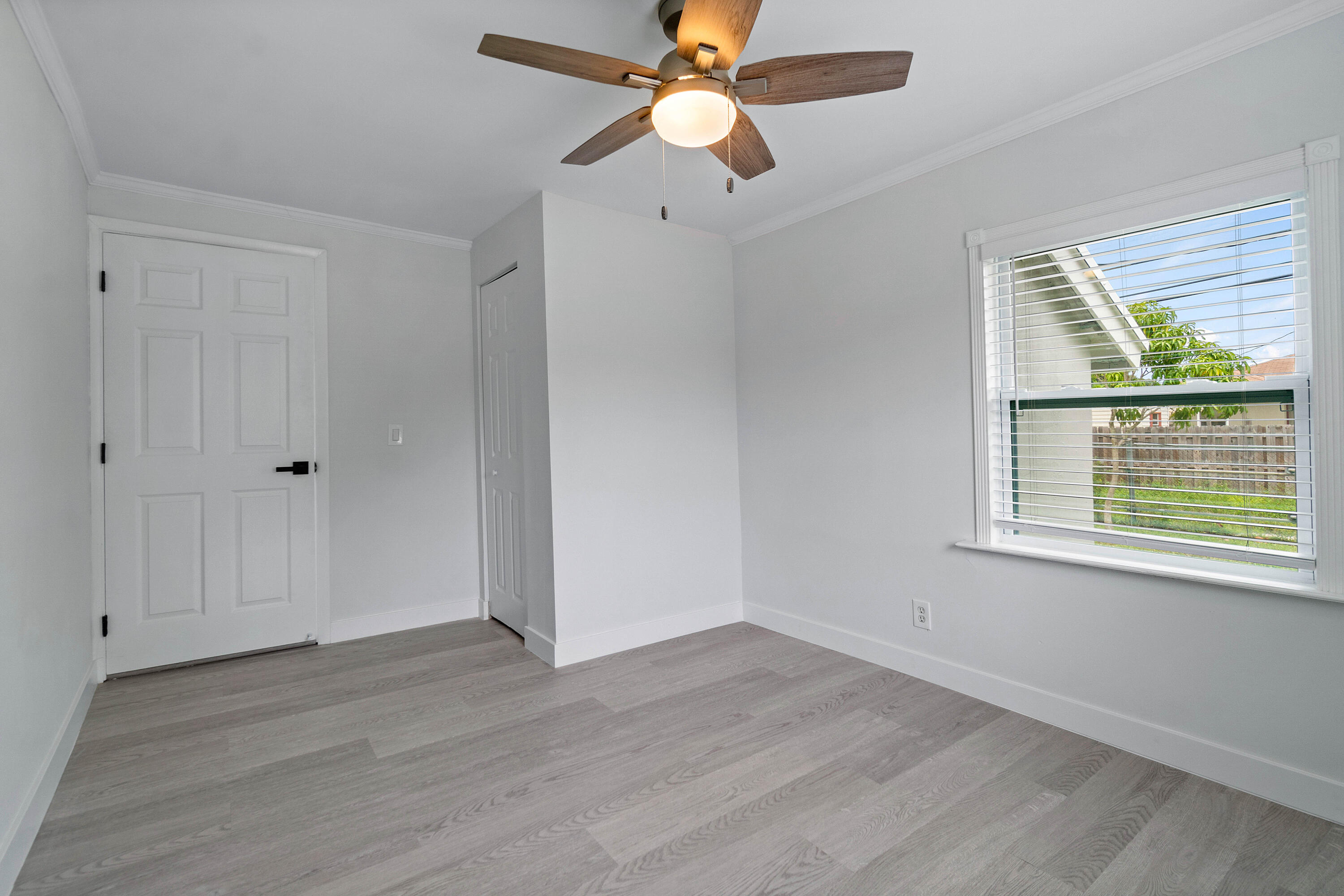 137 Southwest 9th Avenue Delray Beach, FL 33444 - Photo 18 of 26 an empty room with wooden floor a ceiling fan and windows