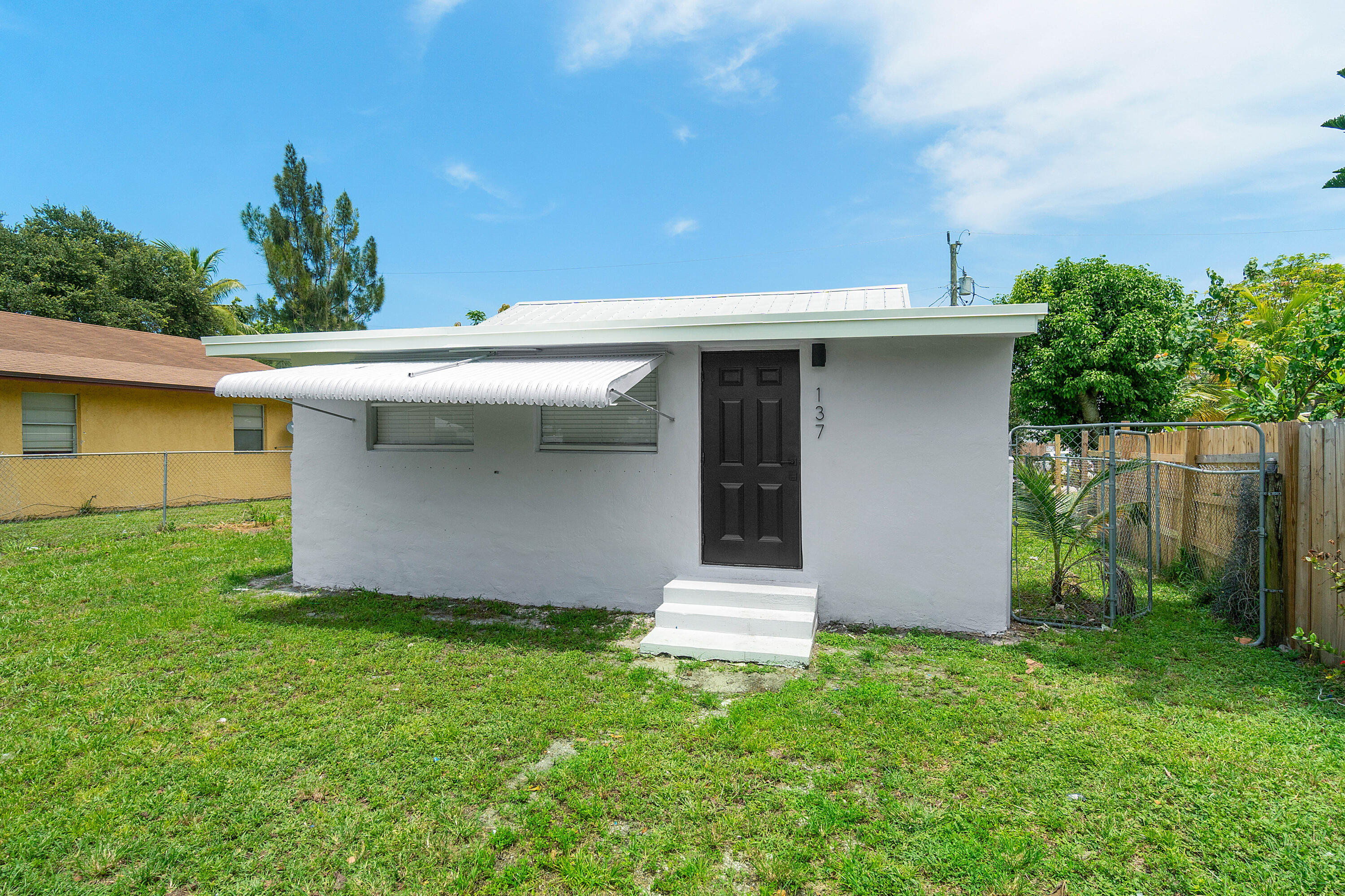137 Southwest 9th Avenue Delray Beach, FL 33444 - Photo 3 of 26 a front view of a house with garden