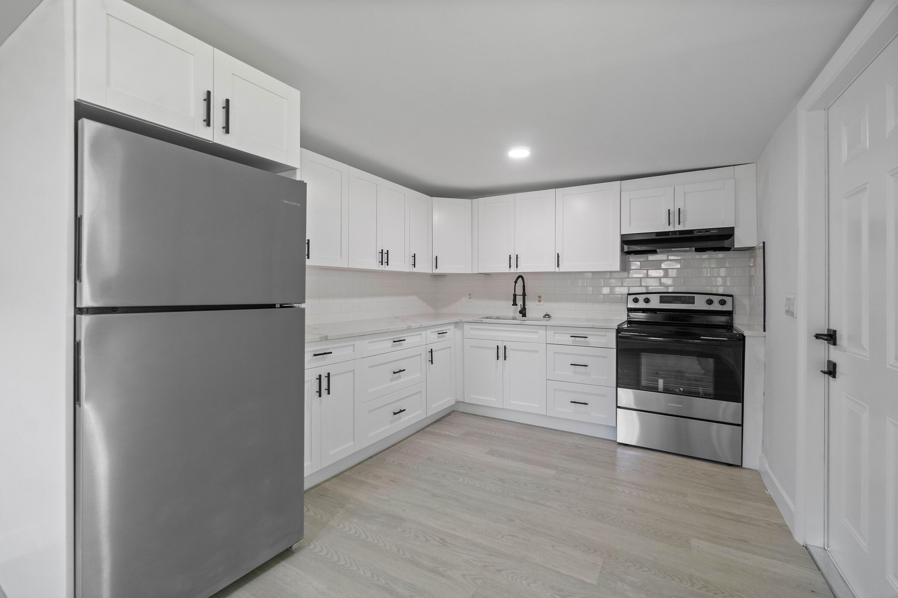 137 Southwest 9th Avenue Delray Beach, FL 33444 - Photo 7 of 26 a kitchen with stainless steel appliances and white cabinets