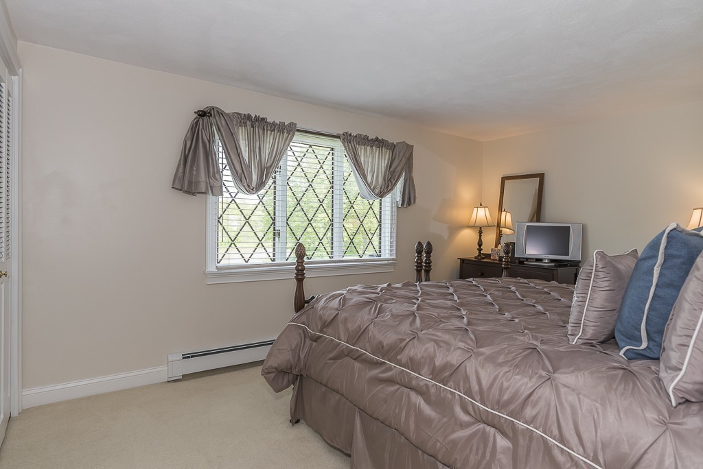 26 Meadow Road Beverly, MA 01915 - Photo 17 of 20 a bedroom with a bed a table with chair and window
