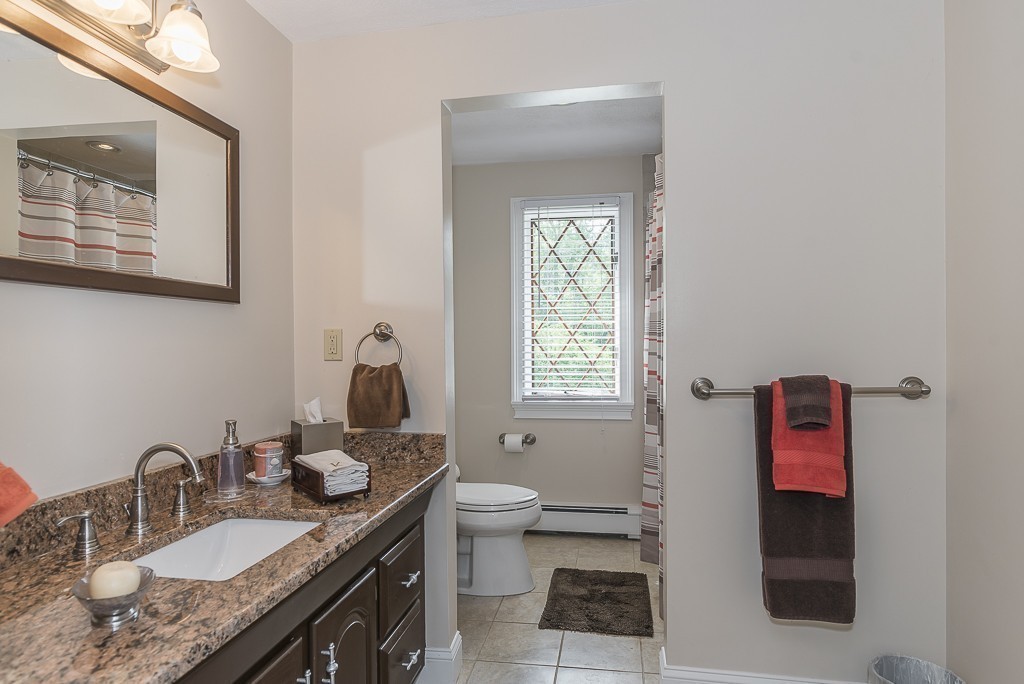 26 Meadow Road Beverly, MA 01915 - Photo 18 of 20 a en suite bathroom with a granite countertop sink a toilet and a mirror