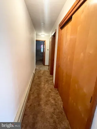 a hallway with wooden floor and stairs