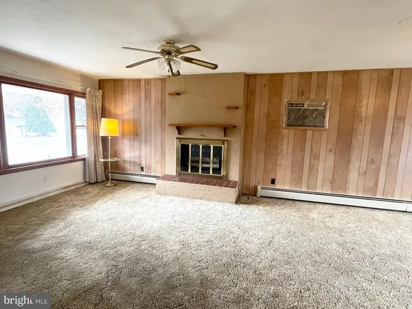 en empty room with windows and fireplace