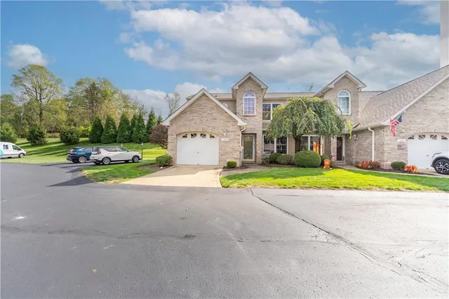 a view of a house with a big yard and large trees