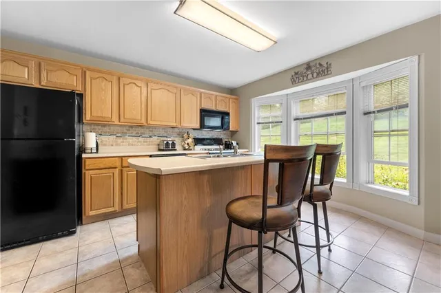a kitchen with a refrigerator a stove a microwave and cabinets
