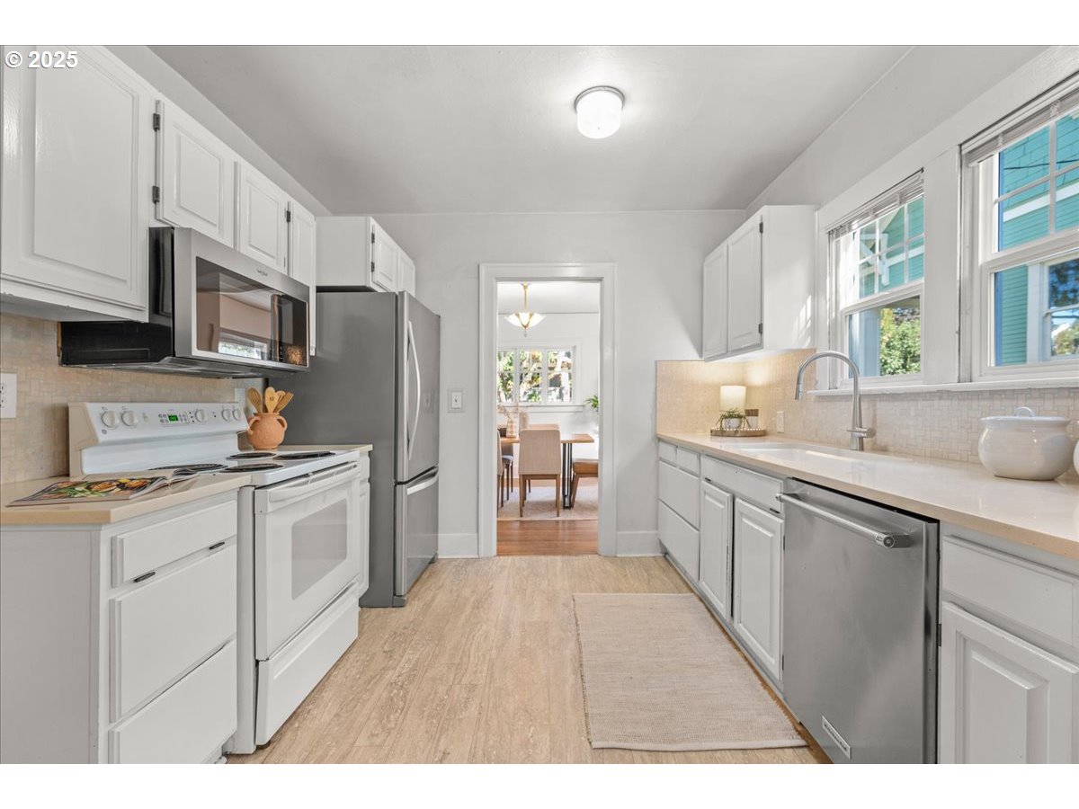 3448 Southeast Sherman Street Portland, OR 97214 - Photo 17 of 40 a kitchen with stainless steel appliances a refrigerator sink and cabinets