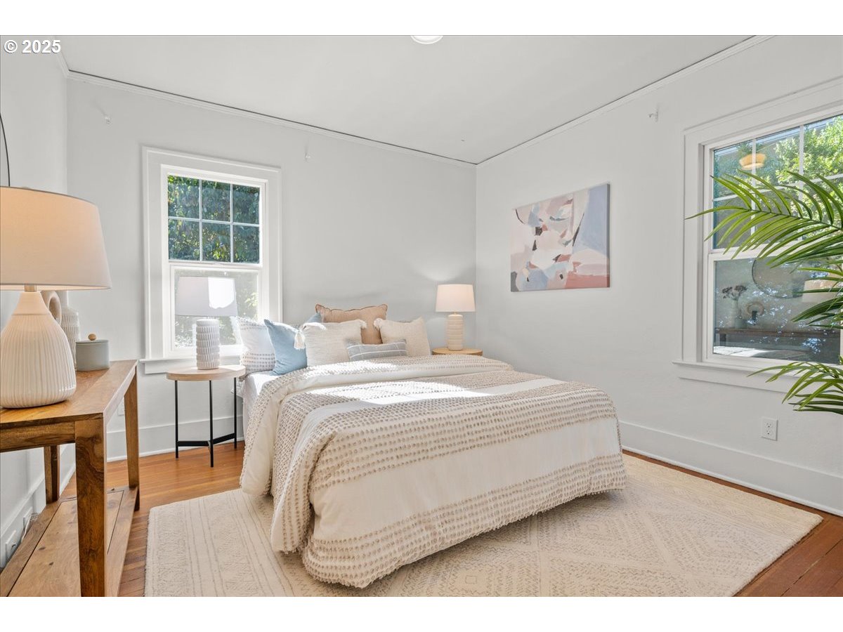3448 Southeast Sherman Street Portland, OR 97214 - Photo 21 of 40 a bedroom with a bed a dresser next to a window