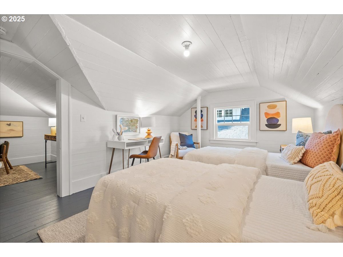 3448 Southeast Sherman Street Portland, OR 97214 - Photo 28 of 40 a bedroom with a large bed and a wooden floor