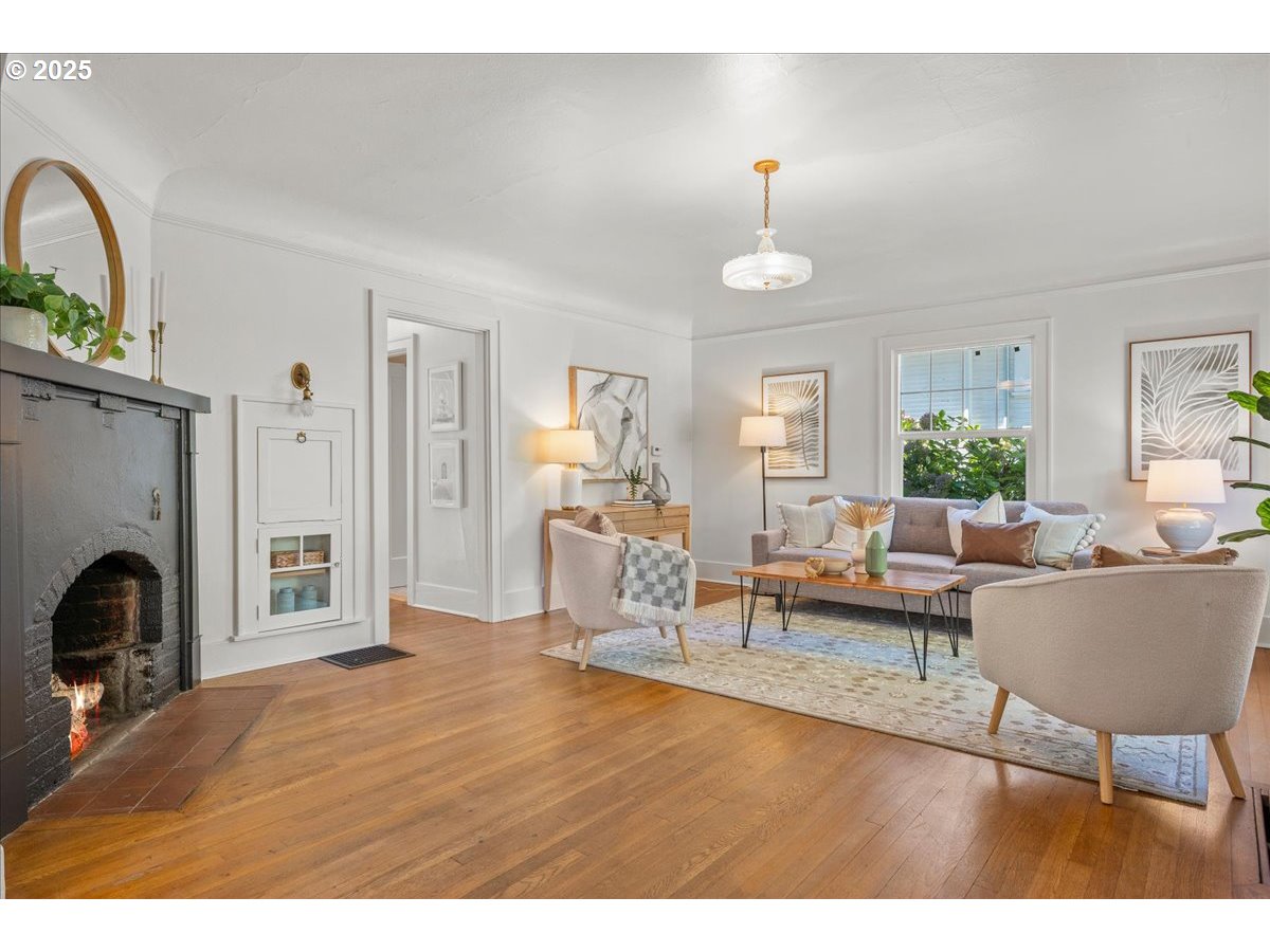 3448 Southeast Sherman Street Portland, OR 97214 - Photo 5 of 40 a living room with furniture a fireplace and a chandelier