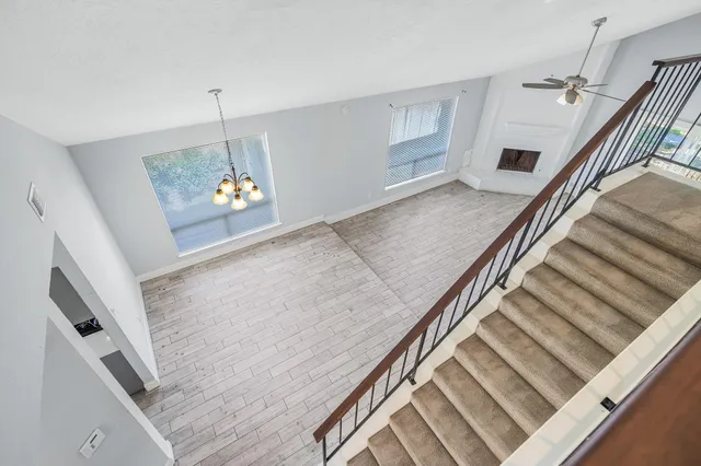a view of a livingroom with wooden floor and stairs