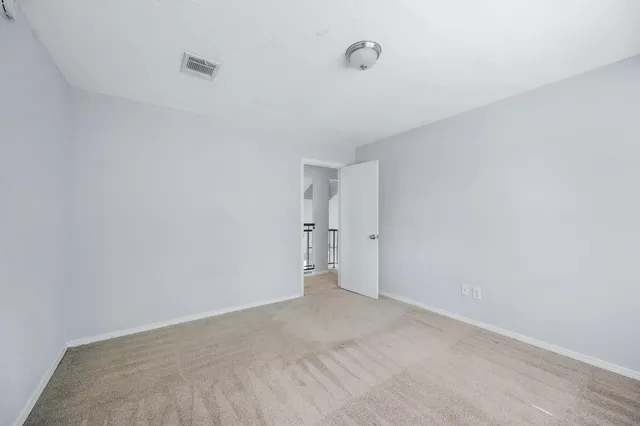 an empty room with a fireplace and a ceiling fan
