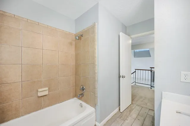 a bedroom with a large bed and a potted plant on the dresser
